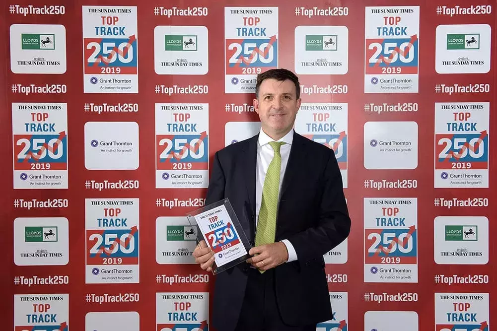 Mark Hudson, CFO at DUAL, holding a Sunday Times Top Track Award