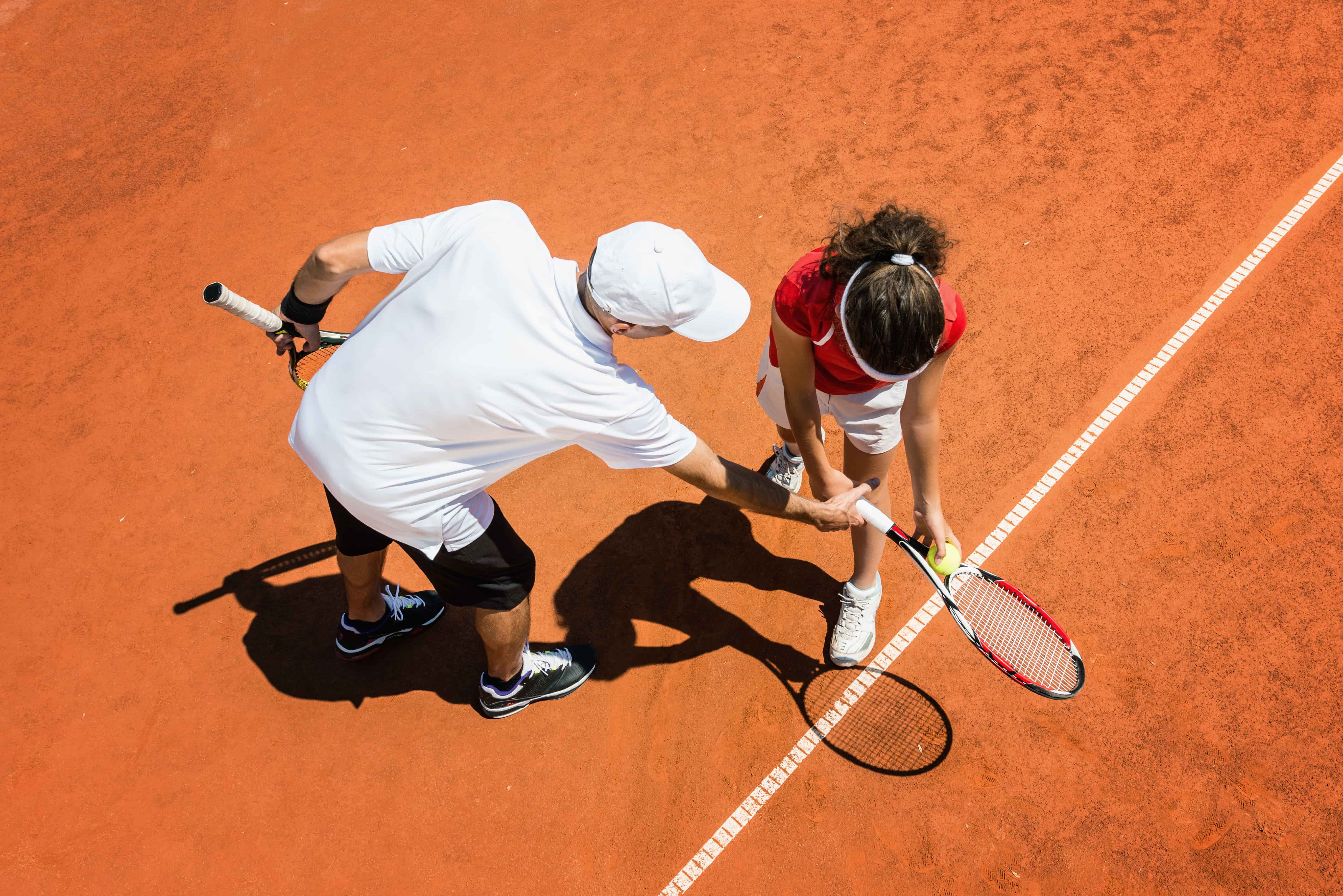 Aerial view of a tennis coach and a young player