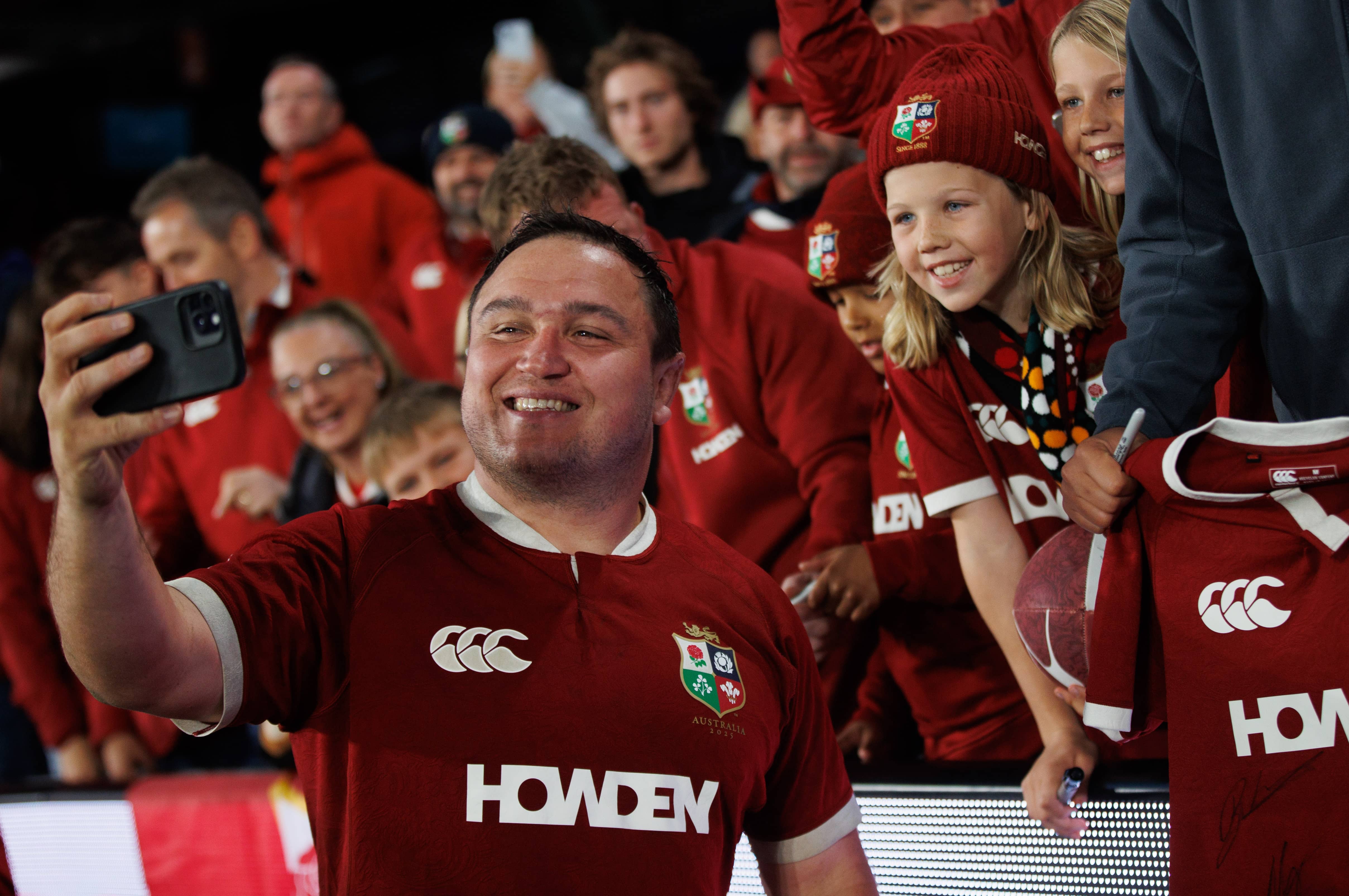Lions rugby player Jamie George taking a selfie with kids after a match
