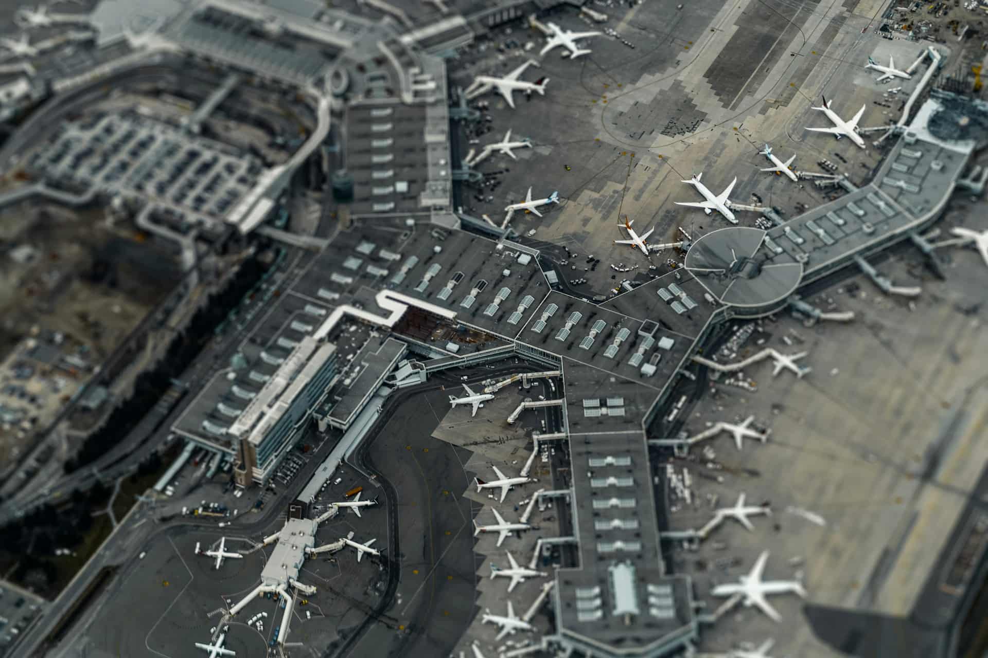 Aerial shot, high above an airport with planes parked outside terminals