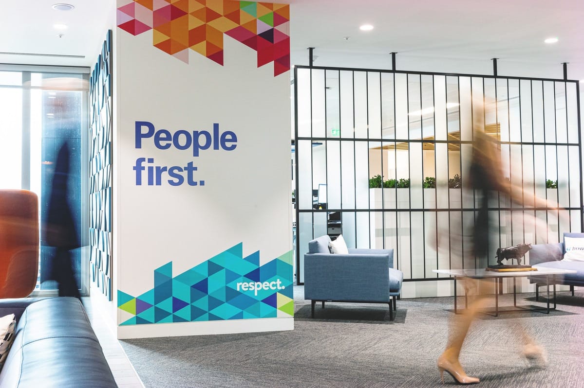 Time lapse image of people passing a sign saying "People First"